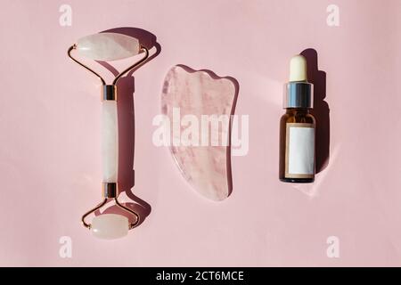 Jade Roller, strumento gua sha e bottiglia di siero cutaneo. Foto Stock