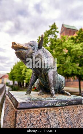 Il maiale seduto come una statua di bronzo sul ponte di canale nella città di Wismar. Foto Stock