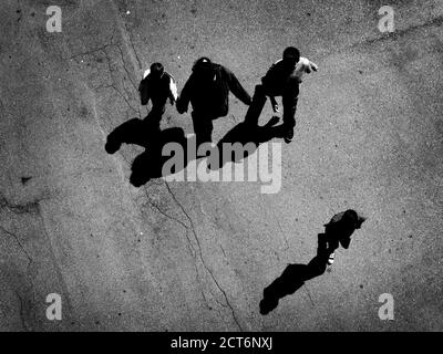 Molte persone che camminano sotto su cemento con ombre aeree vista dall'alto Foto Stock