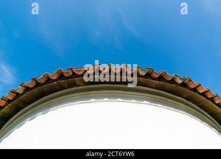 Vista dal basso del bordo di una piastrella circolare tetto su cielo blu Foto Stock