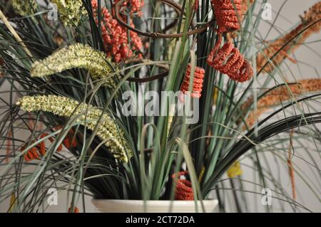 Disposizione dei fiori. Disposizione di fiori multicolore e innaturali in vaso ceramico, zoom fotografico, con messa a fuoco selettiva e sfondo sfocato Foto Stock