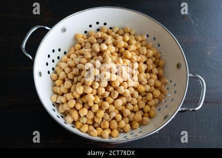 Ceci in ammollo sgocciati in un colino: Fagioli garbanzo secchi che sono stati immersi in acqua e drenati in un colino Foto Stock