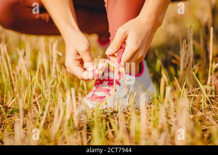 Bella giovane donna che si sciacora e si prepara per attraversare la campagna che corre nel parco Foto Stock