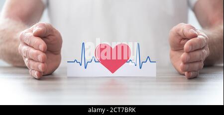 Simbolo heartbeat protetto dalle mani - concetto di assicurazione sanitaria Foto Stock