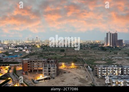 Crepuscolo aereo di bouldings con calde luci arancioni che brillano fuori degli uffici e delle residenze di recente costruzione Foto Stock