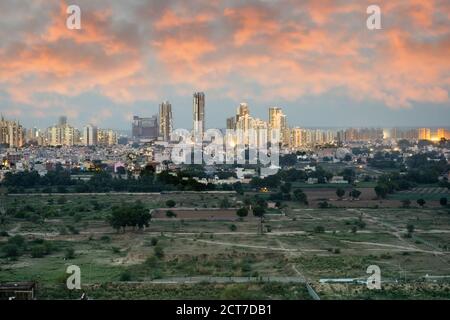 Crepuscolo aereo di bouldings con calde luci arancioni che brillano fuori degli uffici e delle residenze di recente costruzione Foto Stock