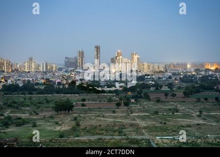 Crepuscolo aereo di bouldings con calde luci arancioni che brillano fuori degli uffici e delle residenze di recente costruzione Foto Stock