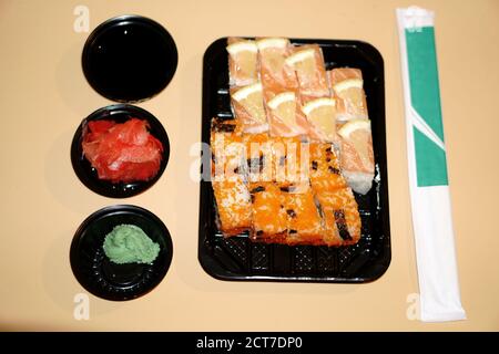 Panini sushi in un contenitore di plastica e spezie extra in un recipiente di plastica Foto Stock