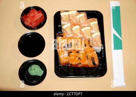Panini sushi in un contenitore di plastica e spezie extra in un recipiente di plastica Foto Stock