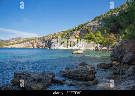 Magnifico paesaggio naturale della popolare spiaggia di 'Zarace' sull'isola di Hvar, meta turistica popolare nel mare Adriatico, circondato da ripide, rocciose cl Foto Stock