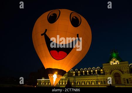 In mongolfiera ad aria calda con giallo Smiley face di notte festival Foto Stock