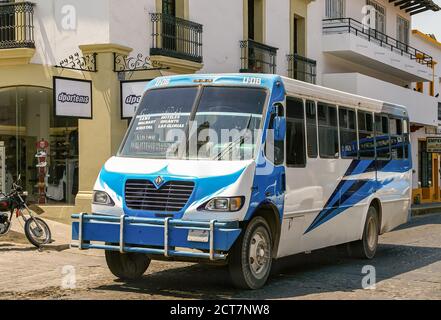 Puerto Vallarta, Messico - 25 aprile 2008: Autobus pubblico blu e bianco parcheggiato in strada centro con facciate di edifici sul retro. Foto Stock