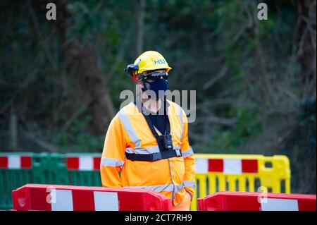 Harefield, Middlesex, Regno Unito. 21 Settembre 2020. Una guardia di sicurezza HS2 in servizio al di fuori della riserva naturale. Oggi numerosi alberi maturi venivano abbattuti da appaltatori HS2 accanto alla Riserva Naturale di Broadwater, un sito di interesse scientifico speciale (SSSI). Il controverso ed eccessivo lavoro di costruzione del collegamento ferroviario ad alta velocità è ora ufficialmente iniziato e l'impatto negativo si sta avvertendo in molte aree rurali lungo la linea del collegamento ferroviario da Londra a Birmingham. 693 siti di fauna selvatica, 108 boschi antichi e 33 SSSI sono a rischio di HS2. Credit: Maureen McLean/Alamy Live News Foto Stock