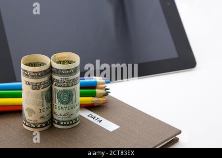 L'investimento di successo si basa su ricerche, dati e fatti visti in simboli di valuta, dati contrassegnati da notebook e tablet digitale. Foto Stock