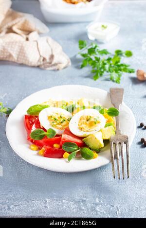 Avocado a fette, uova sode e salmone fritto per colazione Foto Stock