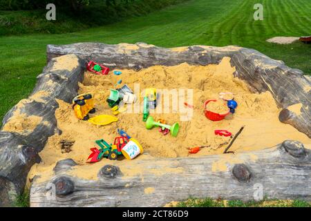 Sandpit, su un parco giochi per bambini, sandpit con vari giocattoli in plastica, escavatore, pale, stampi Sauerland, NRW, Germania Foto Stock