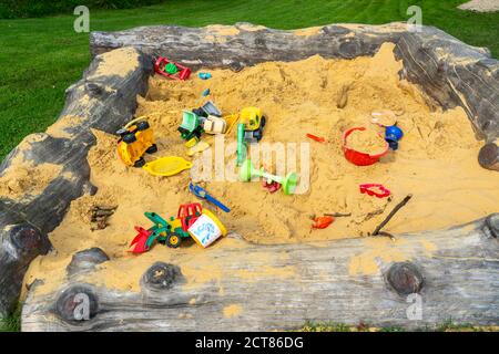 Sandpit, su un parco giochi per bambini, sandpit con vari giocattoli in plastica, escavatore, pale, stampi Sauerland, NRW, Germania Foto Stock