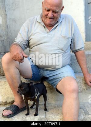 Un uomo maltese con il suo cane da compagnia. Foto Stock