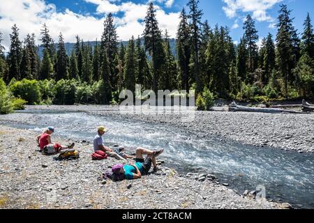 Gli escursionisti riposano lungo il fiume Hoh, Hoh River Trail, Olympic National Park, Washington, USA. Foto Stock