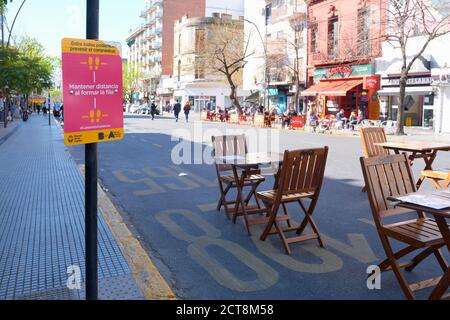 CABA, Buenos Aires / Argentina; 19 settembre 2020: Tavoli allestiti sulla strada, separati l'uno dall'altro, e segni che incoraggiano la distanza sociale, da evitare Foto Stock