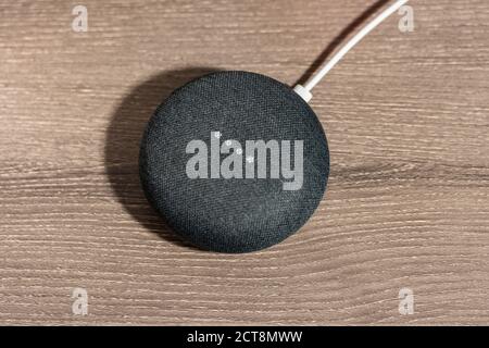 Mini altoparlante grigio Google Home Smart sulla scrivania dell'ufficio Foto Stock