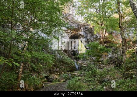vista di una piccola cascata del fiume di montagna tra grandi ciottoli da una scogliera. Foto Stock