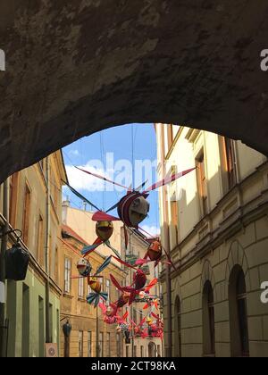 Installazione artistica di pesci volanti decorate strada nella Città Vecchia di Lublino. Pittoresca Piazza del mercato. Pesce divertente decorativo. Idea creativa perfetta. Foto Stock