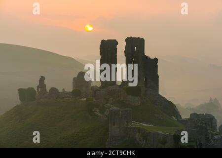 Corfe Castle, Dorset, Regno Unito. 22 settembre 2020. Regno Unito Meteo. Un'alba nebbiosa al castello di Corfe in Dorset con il sole nascente oscurato dalla nube bassa nebbiosa sul solstizio d'autunno. Picture Credit: Graham Hunt/Alamy Live News Foto Stock