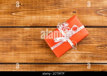 Scatola regalo di Natale rossa su un tavolo di legno Foto Stock
