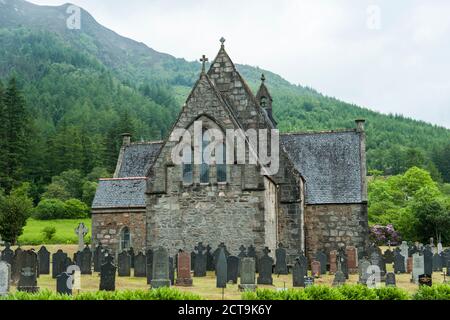 Regno Unito, Scozia, Glen Coe, Ballachulish, vista della chiesa di San Giovanni Evangelista con lapidi del cimitero nella parte anteriore Foto Stock
