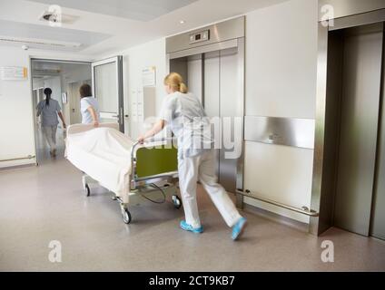 Germania, Freiburg, infermieri spostando letto di ospedale Foto Stock