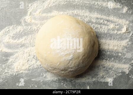 Impasto palla e farina su sfondo grigio Foto Stock