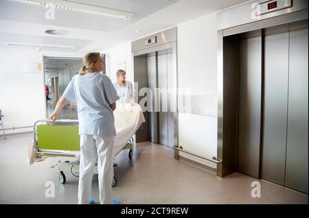 Germania, Freiburg, infermieri spostando letto di ospedale Foto Stock