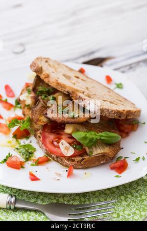 Fette di pane fritto con oystermuhrooms e pomodori Foto Stock