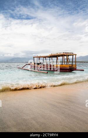 Indonesia, Lombok, Isola Gili Air, barca di legno tradizionale presso la spiaggia Foto Stock