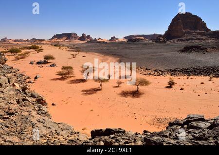 Algeria, Sahara, del Tassili N'Ajjer National Park, gruppo di turisti in appoggio in un secco valle rocciosa Foto Stock