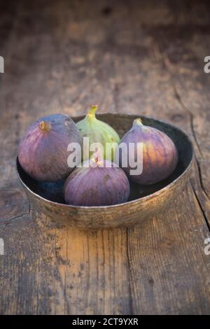 Ciotola con quattro figure (Ficus carica) sul tavolo di legno, studio shot Foto Stock