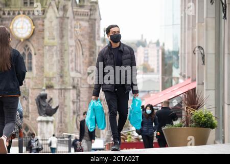 Immagine scattata il giorno in cui le restrizioni di Coronavirus sono state applicate a Birmingham. Nella foto è stato raffigurato un acquirente vicino all'arena nel centro città con una copertura facciale. Foto Stock