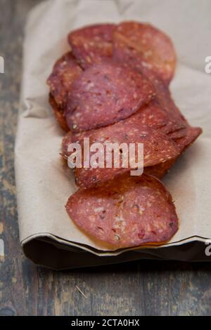 Salame di affettare sul tavolo di legno Foto Stock