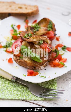 Fette di pane fritto con oystermuhrooms e pomodori Foto Stock