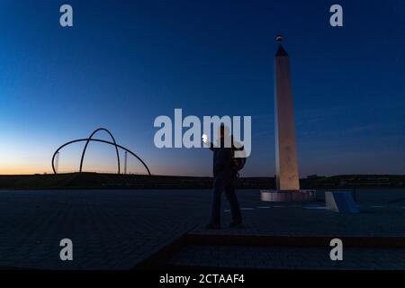 Atmosfera serale a Halde Hoheward, la più grande discarica di rifiuti minerari nella zona della Ruhr, l'osservatorio all'orizzonte e l'obelisco della meridiana, tra Hert Foto Stock