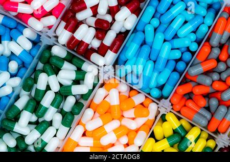 Vista dall'alto di pillole di capsule di antibiotici nel vassoio di plastica resistenza agli antibiotici. Prodotti farmaceutici. Sanità e medicina. Cornice completa di rosso, blu, Foto Stock