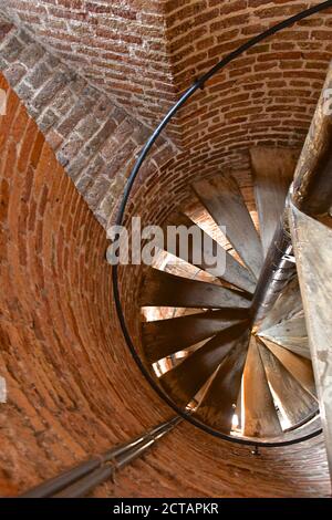 Si affaccia su una vecchia scala a chiocciola in legno in una torretta circolare in mattoni in una vecchia torre medievale in mattoni. Foto Stock