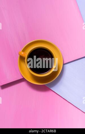 Caldo caffè nero aromatico americano su un vecchio tavolo di legno rosa blu con foglie d'autunno. Caffè caldo. Foto Stock