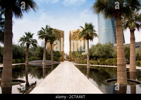 Il monumento d'oro per celebrare il giubileo della Costituzione Kuwait con palme e fontana di fronte. Al Shaheed Park, Kuwait. Foto Stock