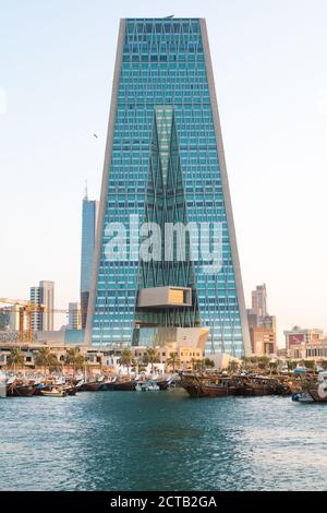 Fiocchi di legno tradizionali arabi di fronte ai grattacieli Kuwait nella bella luce della sera. Foto Stock