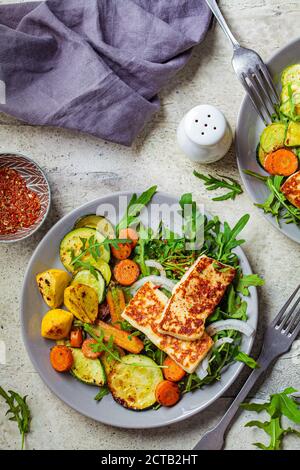 Alloumi alla griglia con verdure alla griglia su un piatto grigio. Concetto di cibo vegetariano. Foto Stock