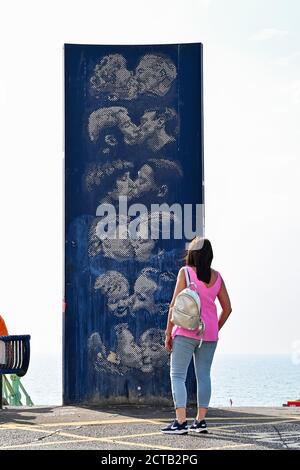 Brighton UK 22 settembre 2020 - i visitatori godono di un altro giorno di sole caldo dalla scultura del muro di Bacio di Bruce Williams sul lungomare di Brighton oggi, ma il tempo è previsto per condizioni molto più fresche da domani in poi: Credit Simon Dack / Alamy Live News Foto Stock