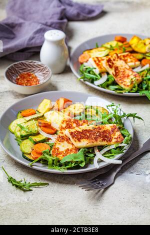 Alloumi alla griglia con verdure alla griglia su un piatto grigio. Concetto di cibo vegetariano. Foto Stock