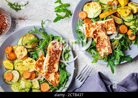 Alloumi alla griglia con verdure alla griglia su un piatto grigio. Concetto di cibo vegetariano. Foto Stock